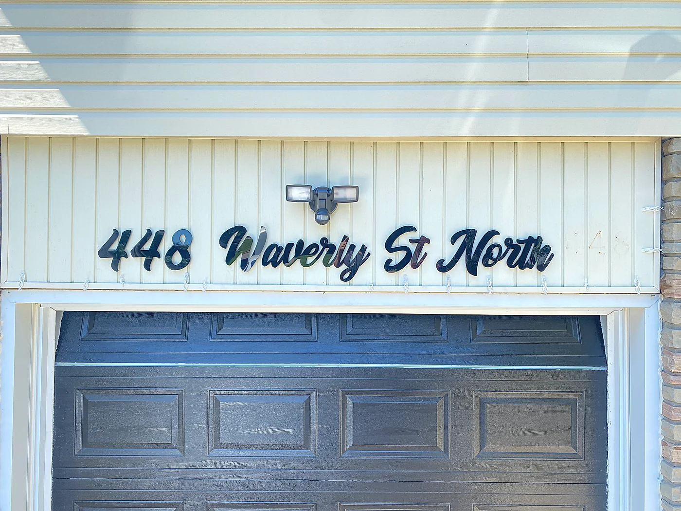 448 Waverly St North in black script above a garage door