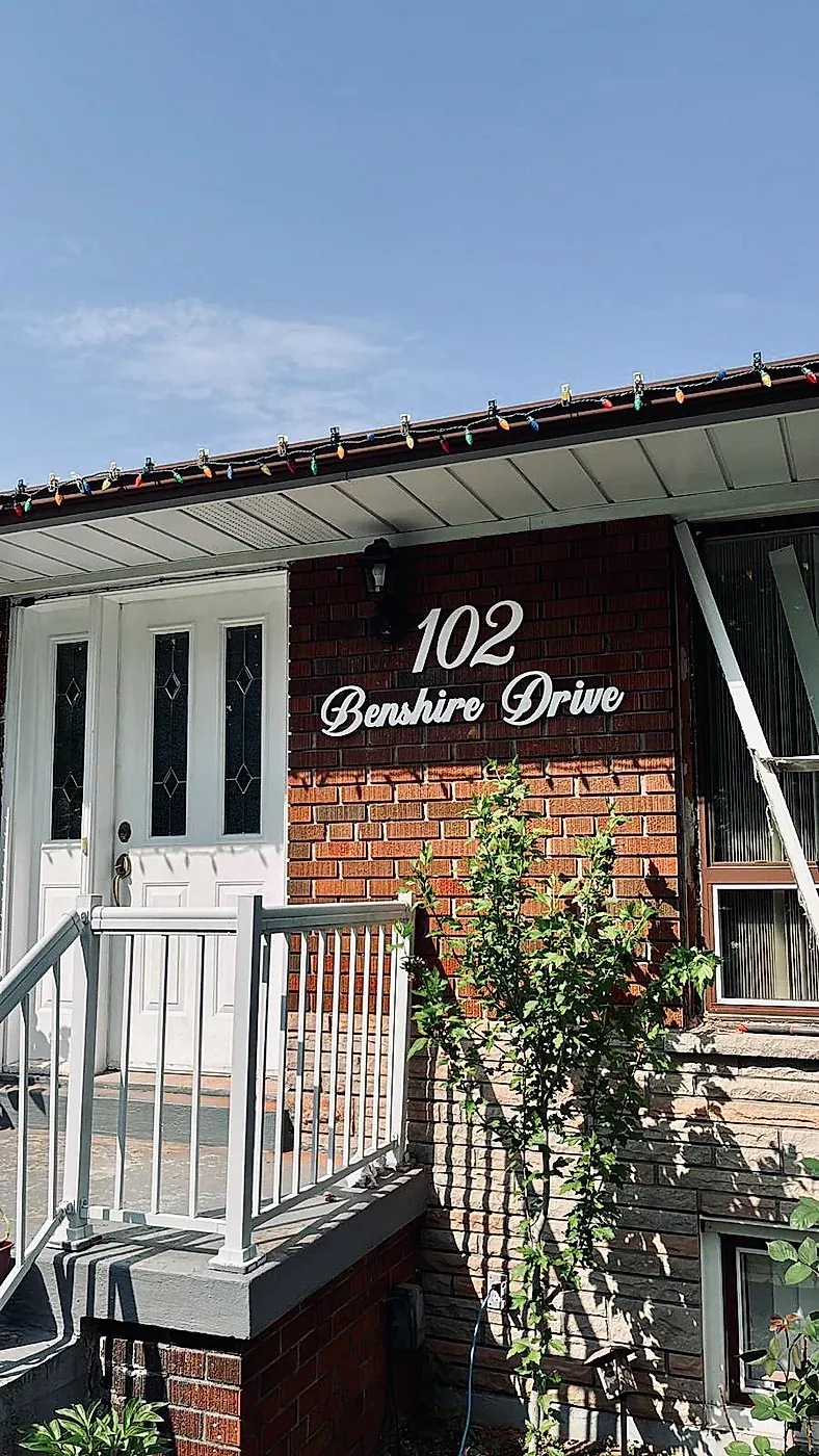 102 Benshire Drive on a red brick porch wall