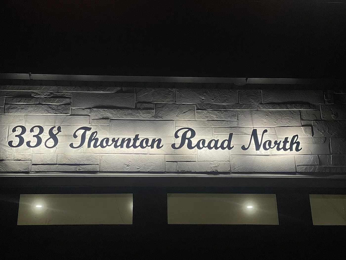 338 Thornton Road North lit across a stone fascia at night